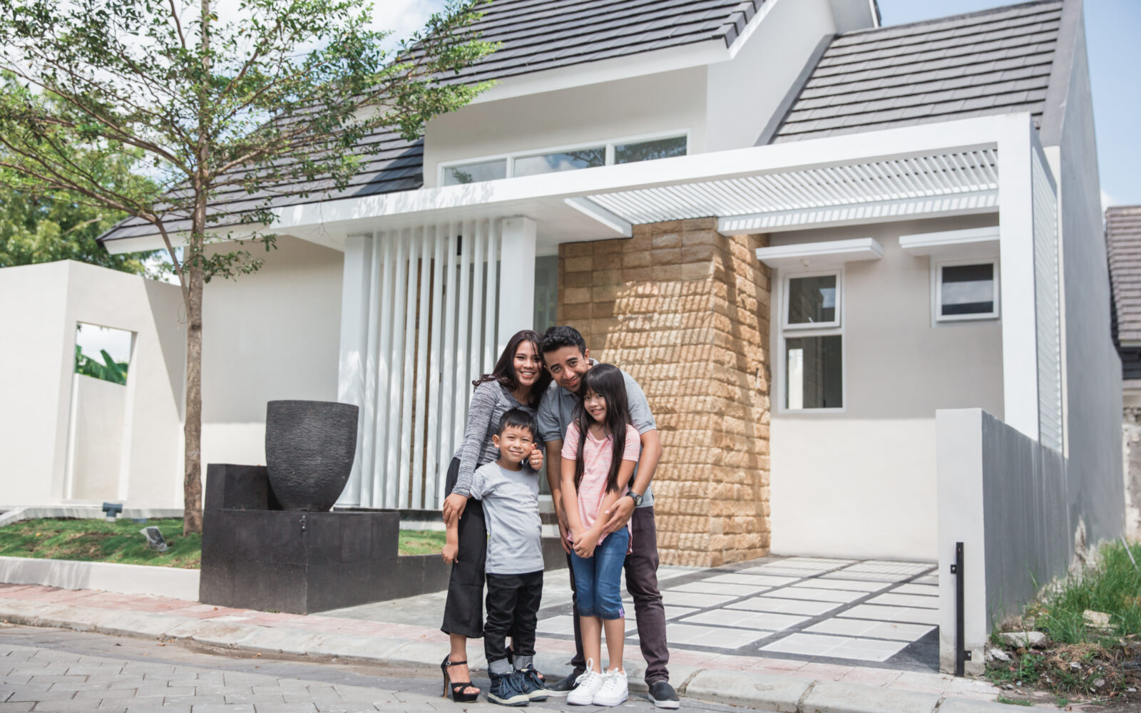 happy asian family in front of their house